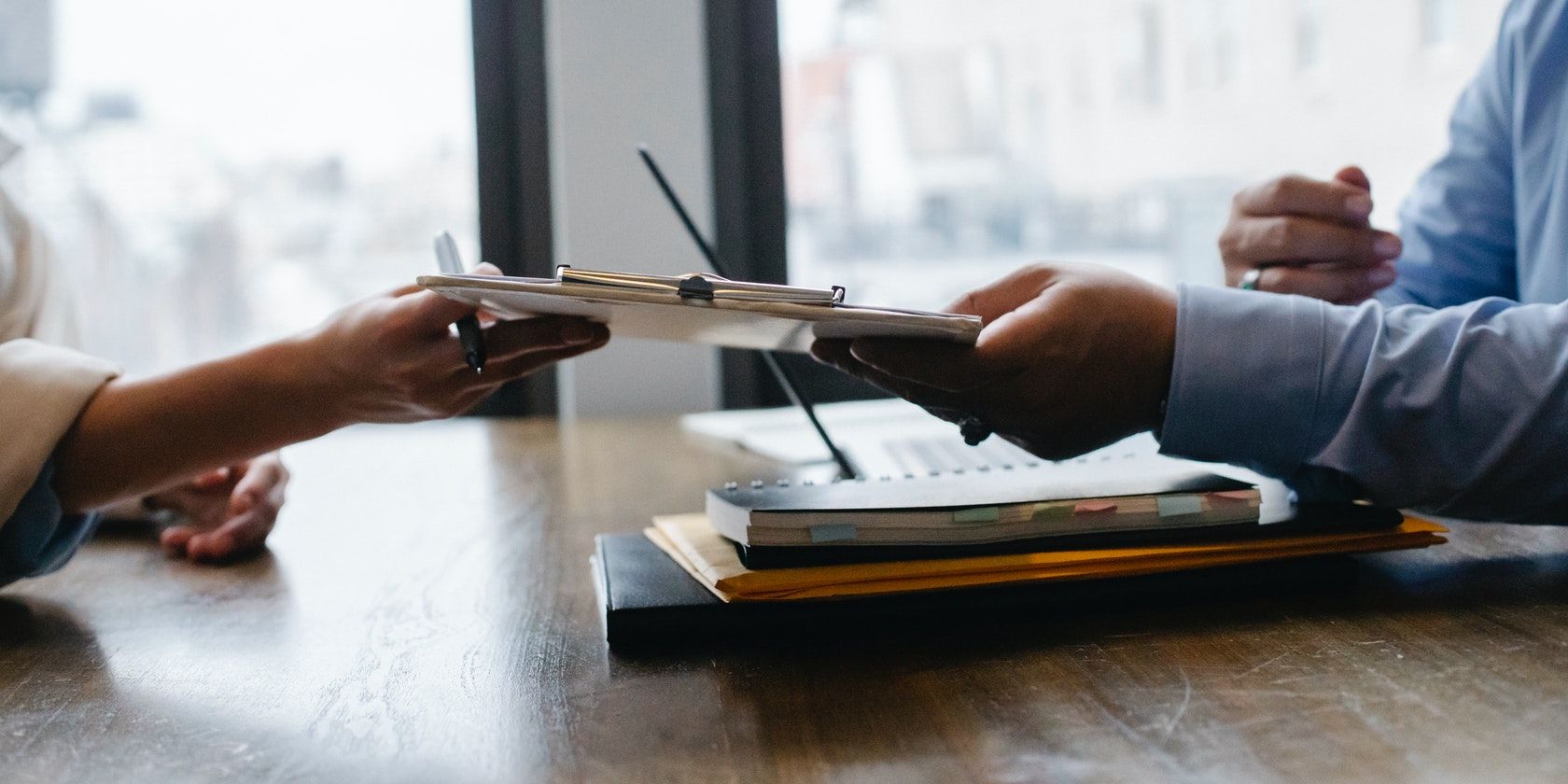 Два человека обмениваются планшетом