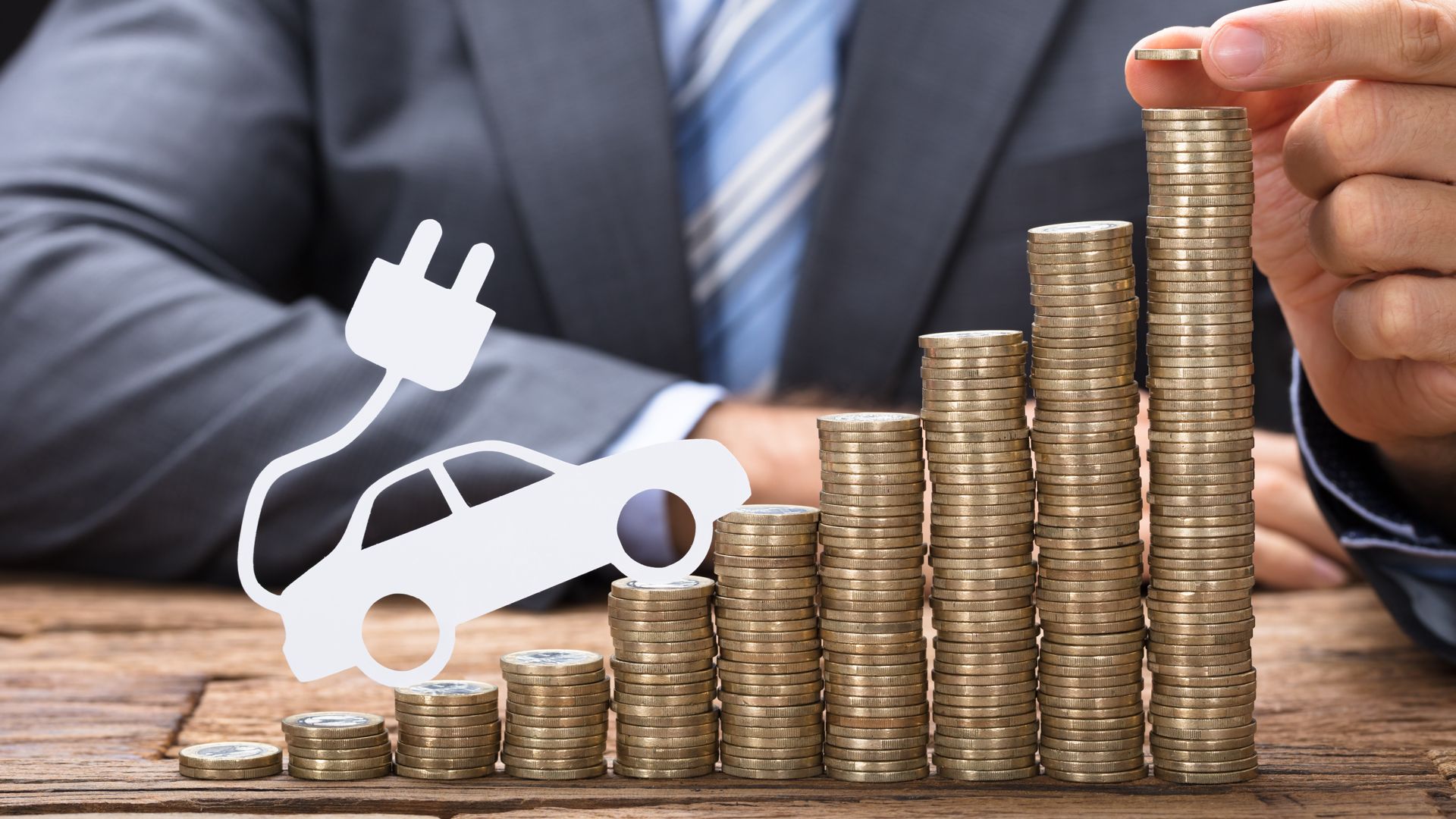 Стопка денег и электромобиль.