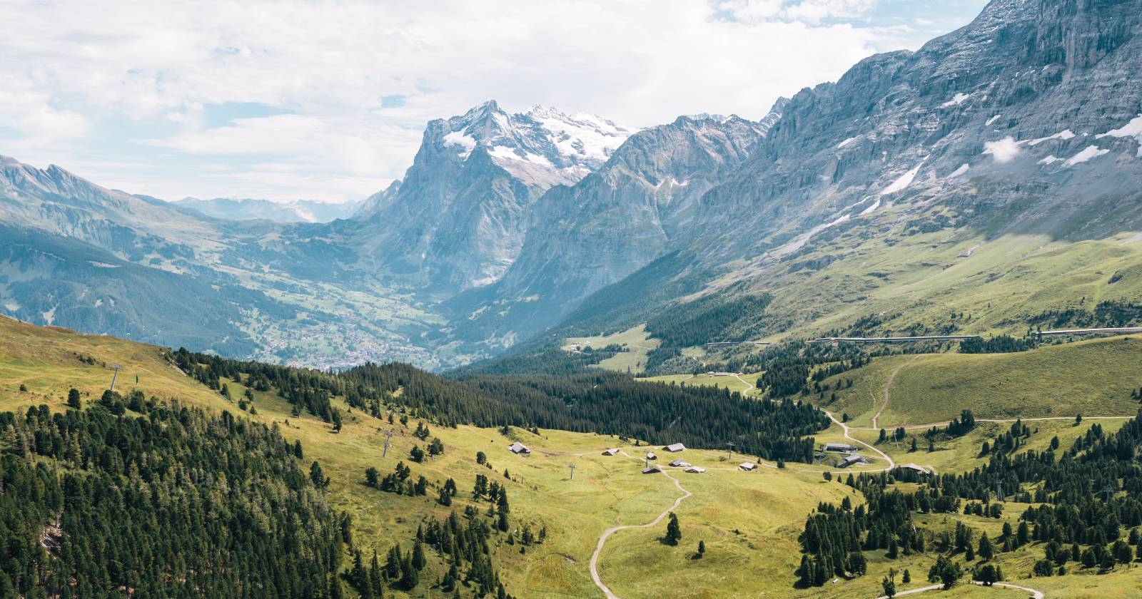 Панорама гор в Швейцарии, взятая с высоты, с глубокими долинами и ярким небом