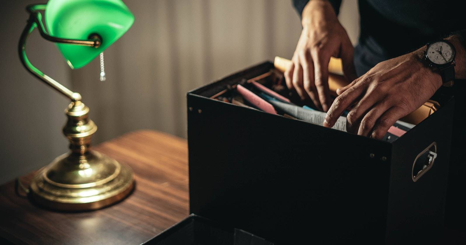 Пара рук в коробке с файлами