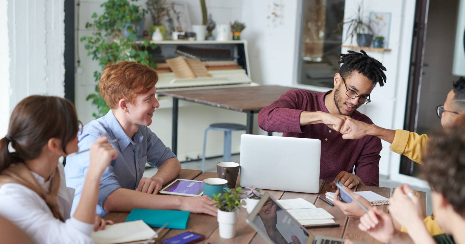 Сотрудники бьют кулаками в знак командного единения