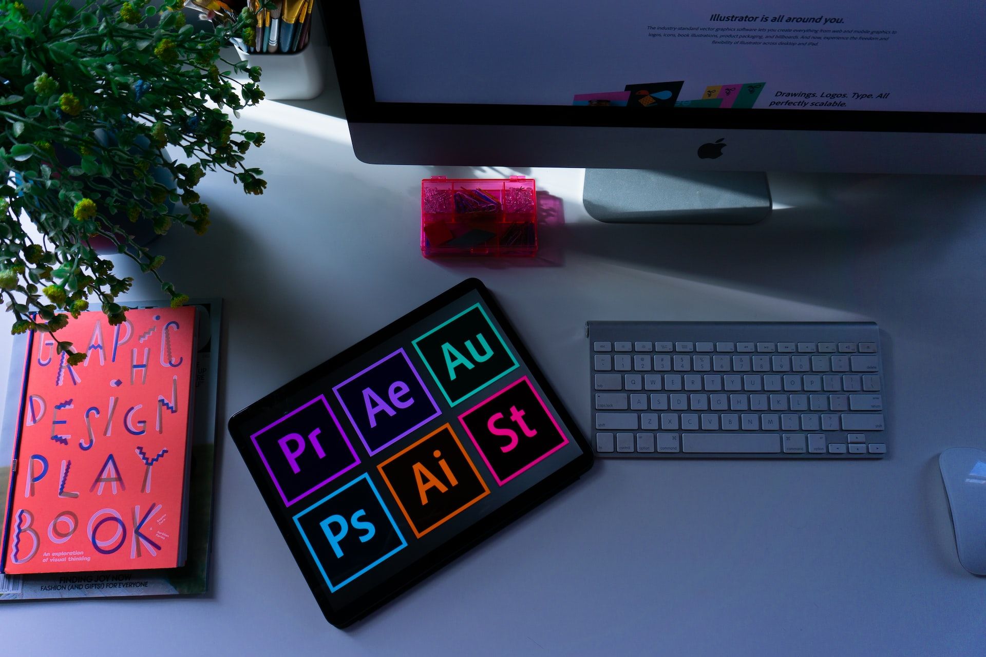 Логотипы Adobe рядом с компьютером