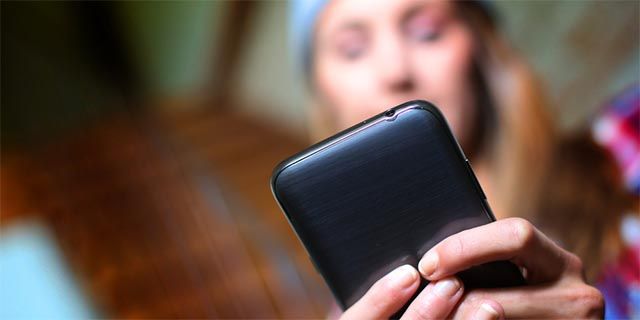 Подросток с смартфоном и лентой соцсетей