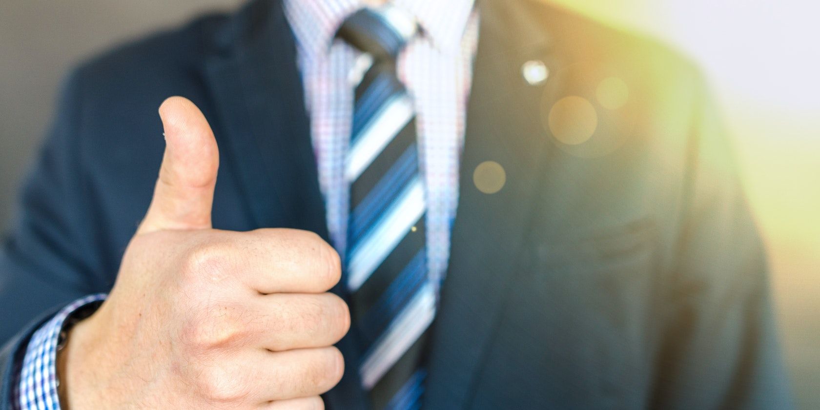 Мужчина в костюме показывает палец вверх