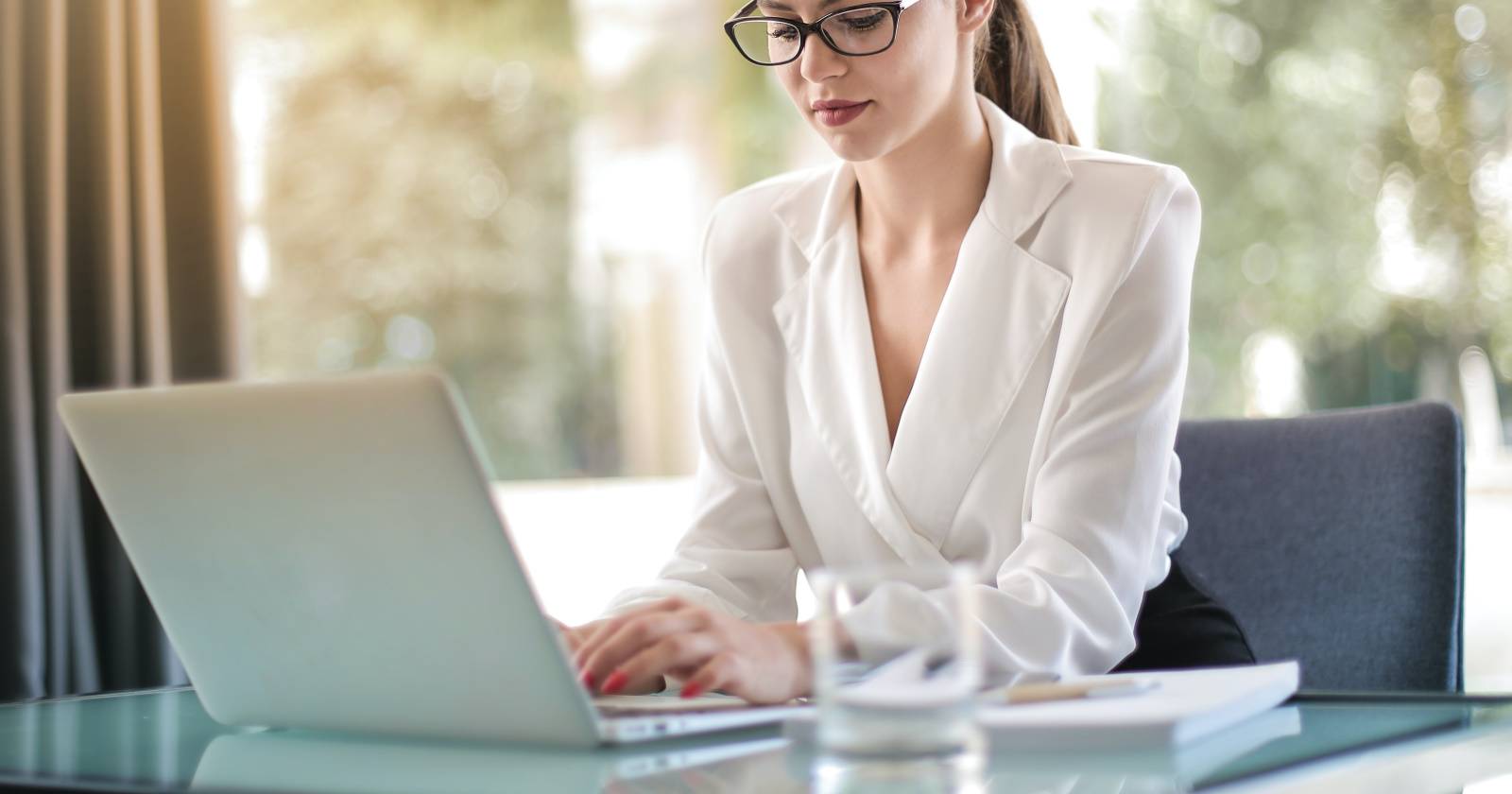 Женщина печатает на ноутбуке в рабочем пространстве