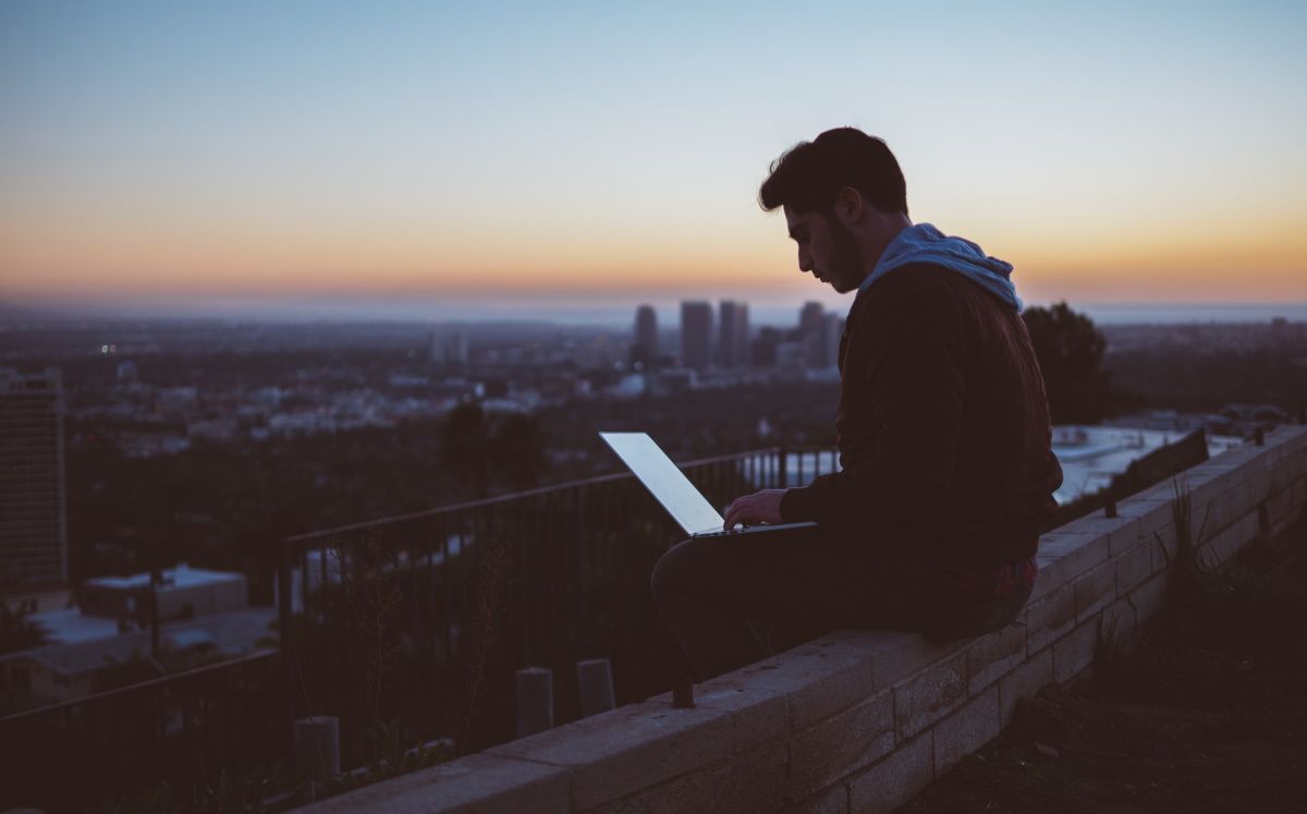 Человек работает на компьютере на улице