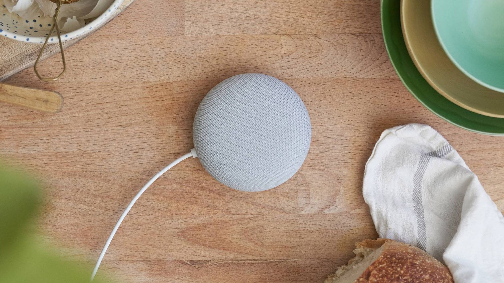 Google Nest Mini стоит на столе.