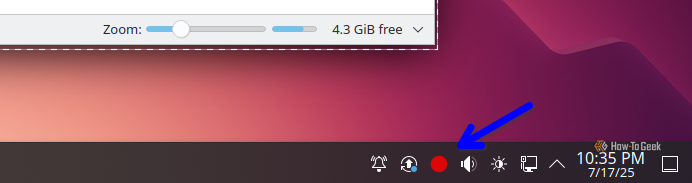 Blue arrow pointing to a red dot indicating a video is being recorded with Spectacle.