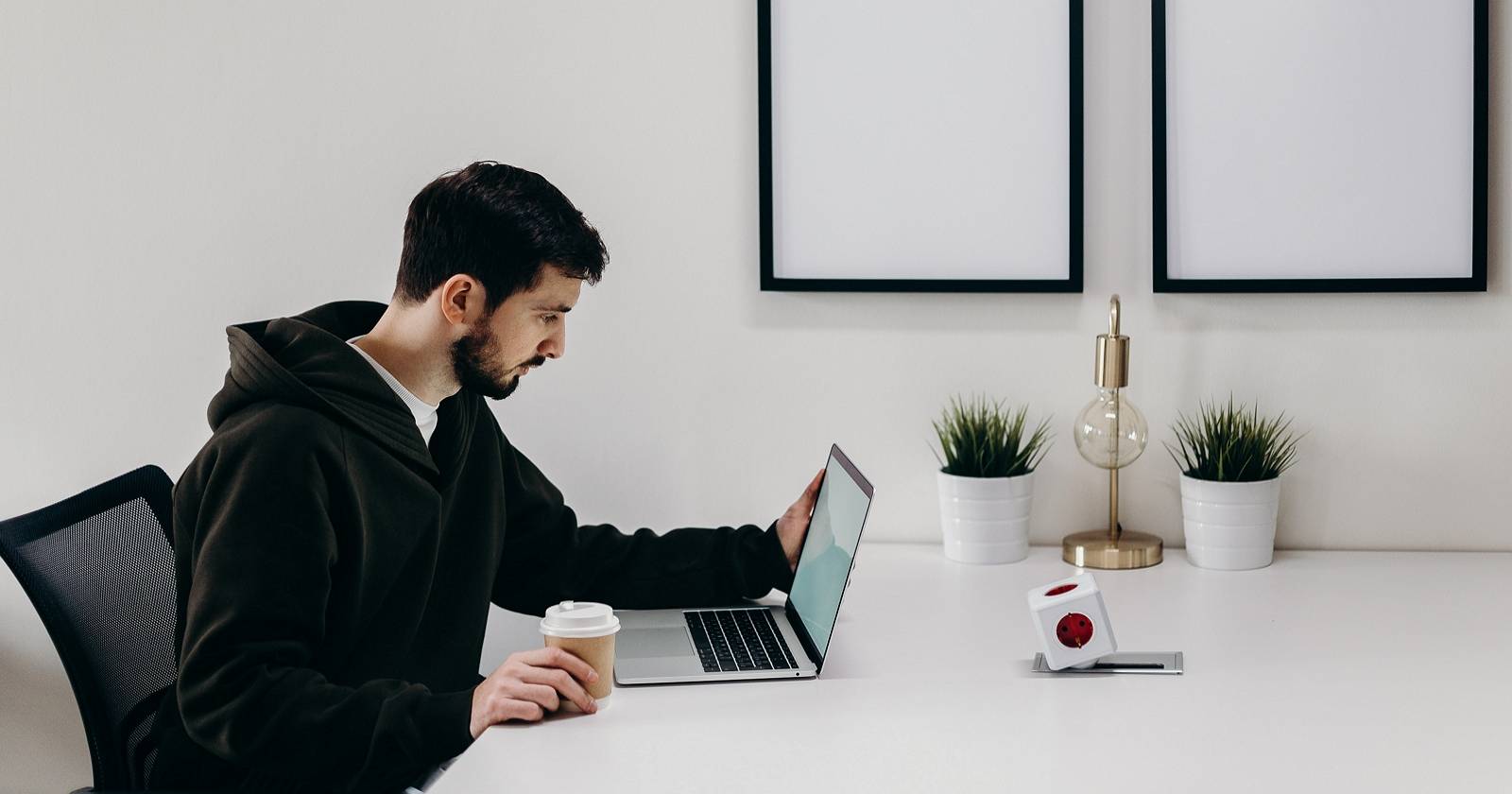 Мужчина в черном пальто сидит за столом