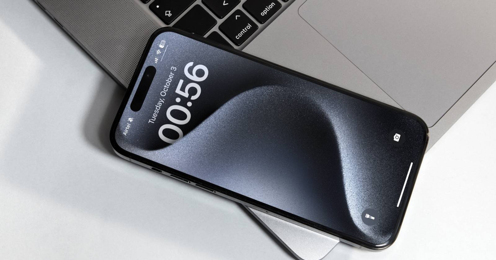 iPhone 15 Pro на ноутбуке — виден экран блокировки