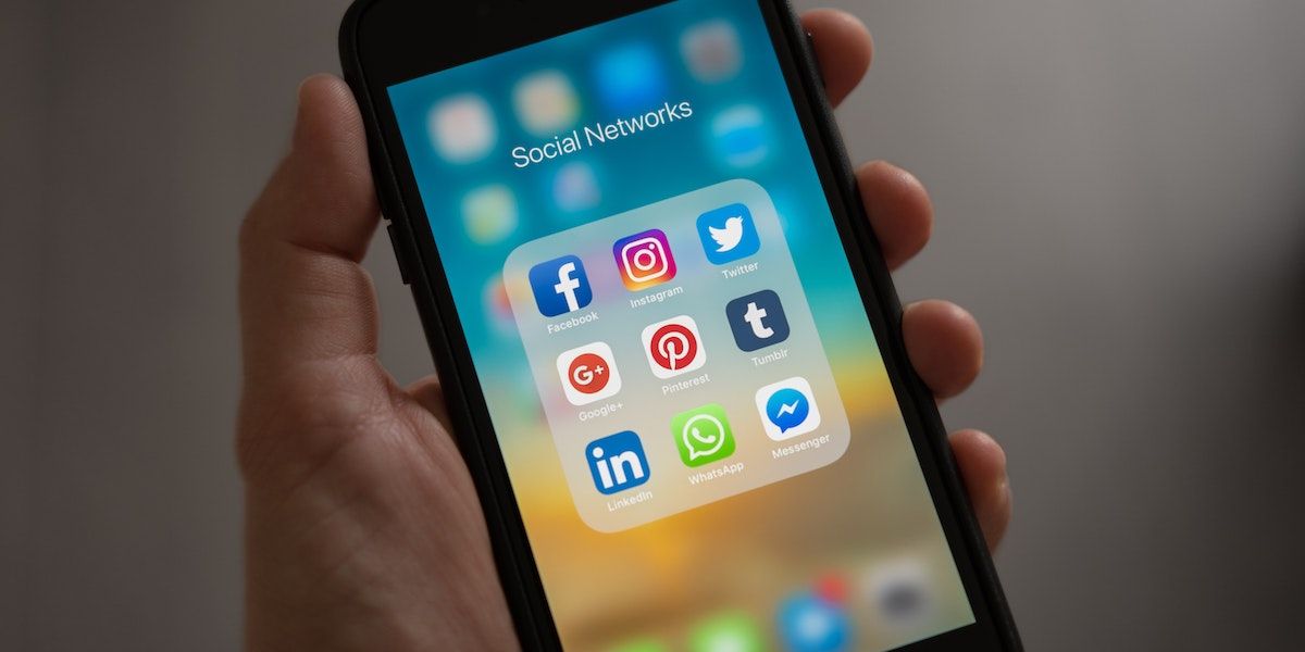 Person-Holding-Iphone-Showing-Social-Media-apps