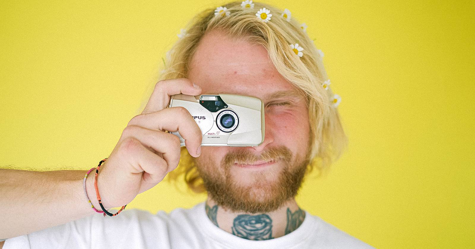 Мужчина делает снимок компактной камерой