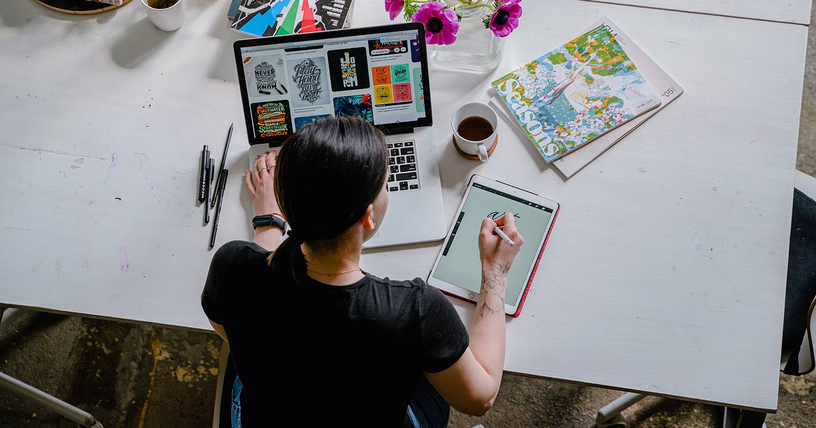 Графический дизайнер работает за белым столом