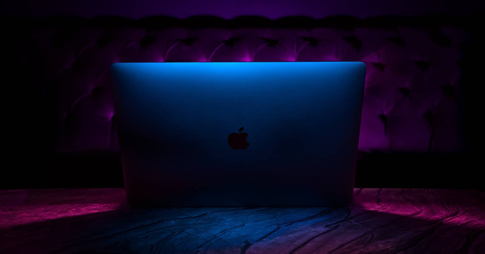 MacBook Pro в тёмной атмосфере на фоне рабочего стола