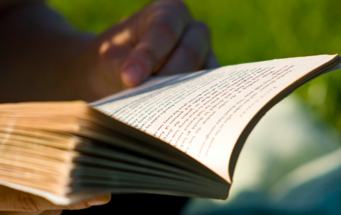 Человек читает книгу на кресле