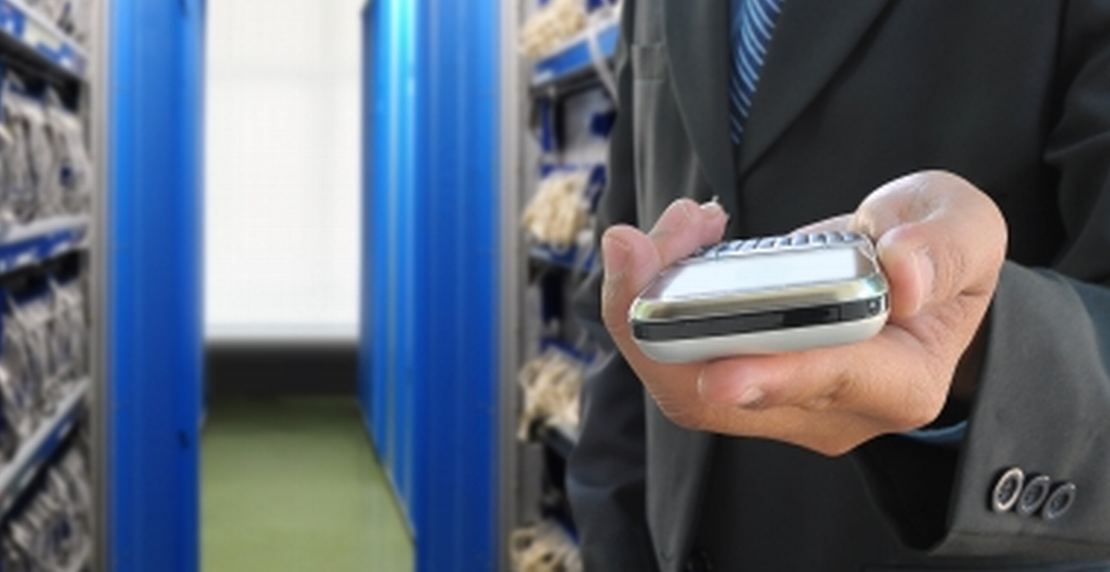 Рука с телефоном, отправляющая SMS для удалённого управления компьютером