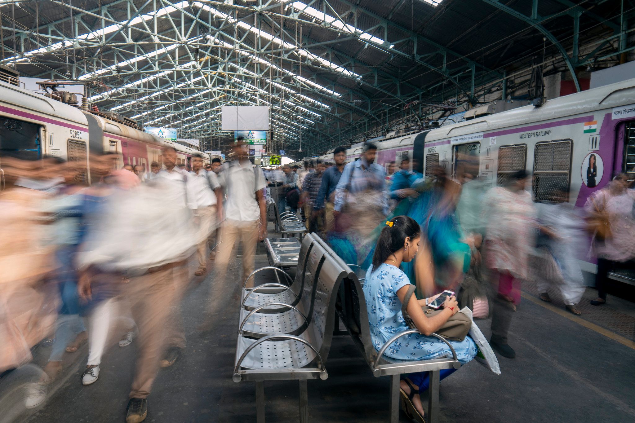 Woman sitting still while crowd is blurred