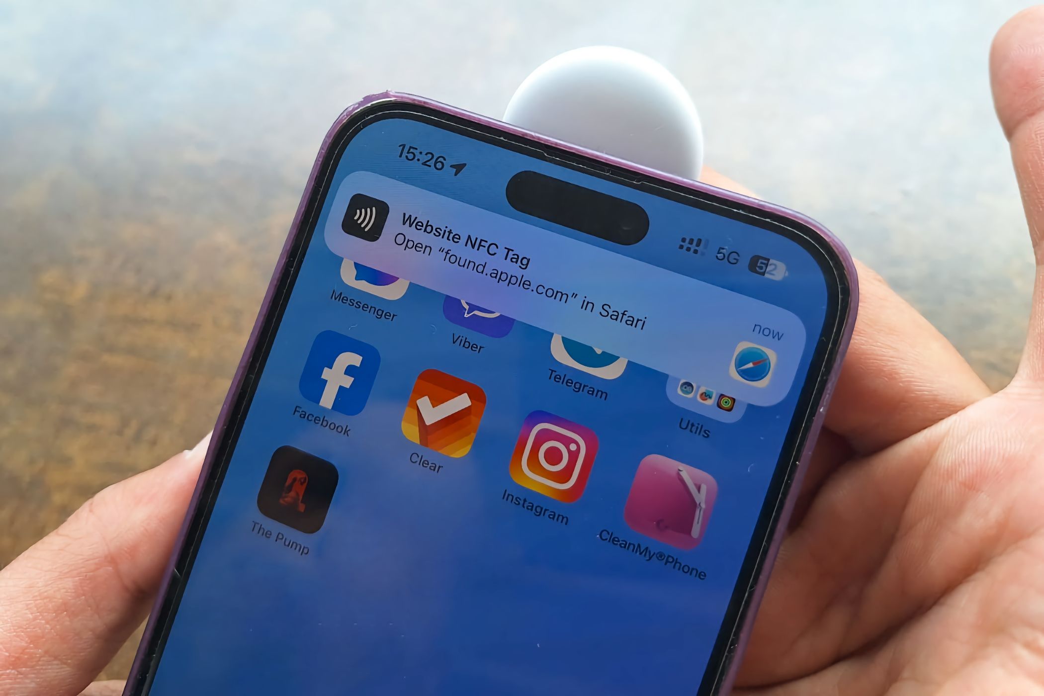 Сканирование AirTag, приложенного к верхней части iPhone.