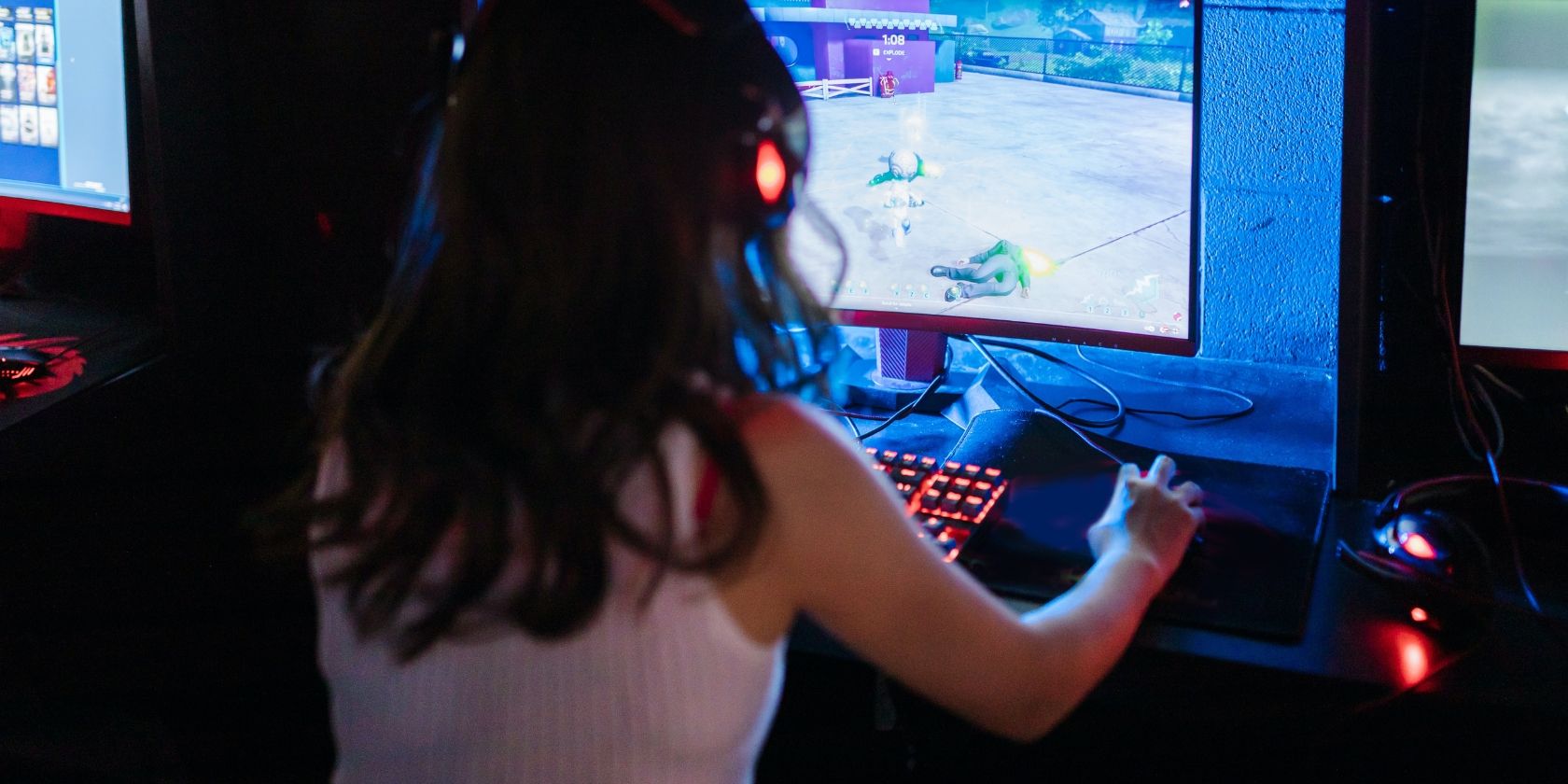 a girl wearing a headset and playing a game at a computer