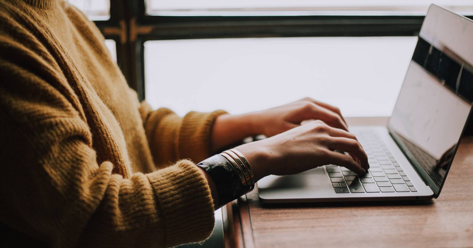 Фото человека, работающего за ноутбуком