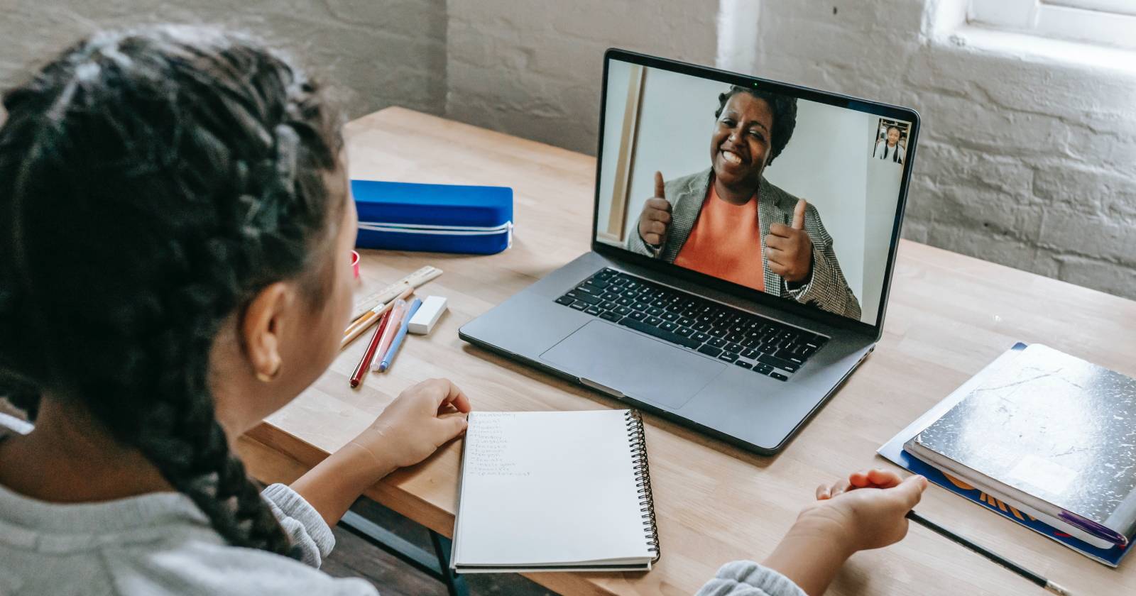 Женщина обучает девочку за ноутбуком