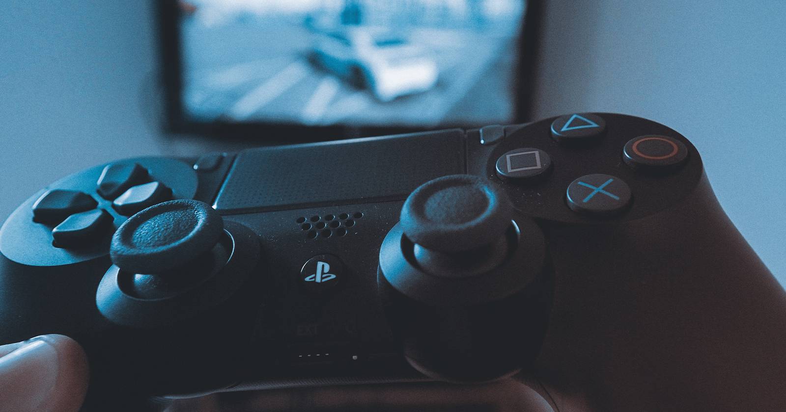 Левая рука держит контроллер PS4