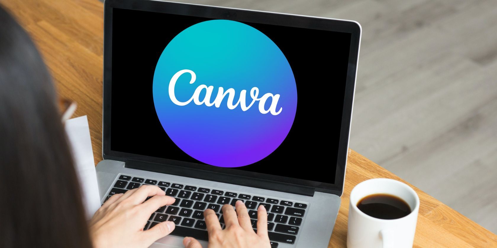 Женщина работает за ноутбуком, на экране логотип Canva