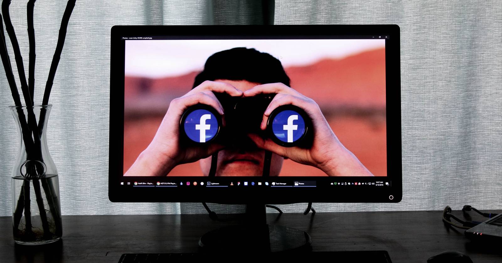 Экран компьютера с иконкой Facebook и биноклем