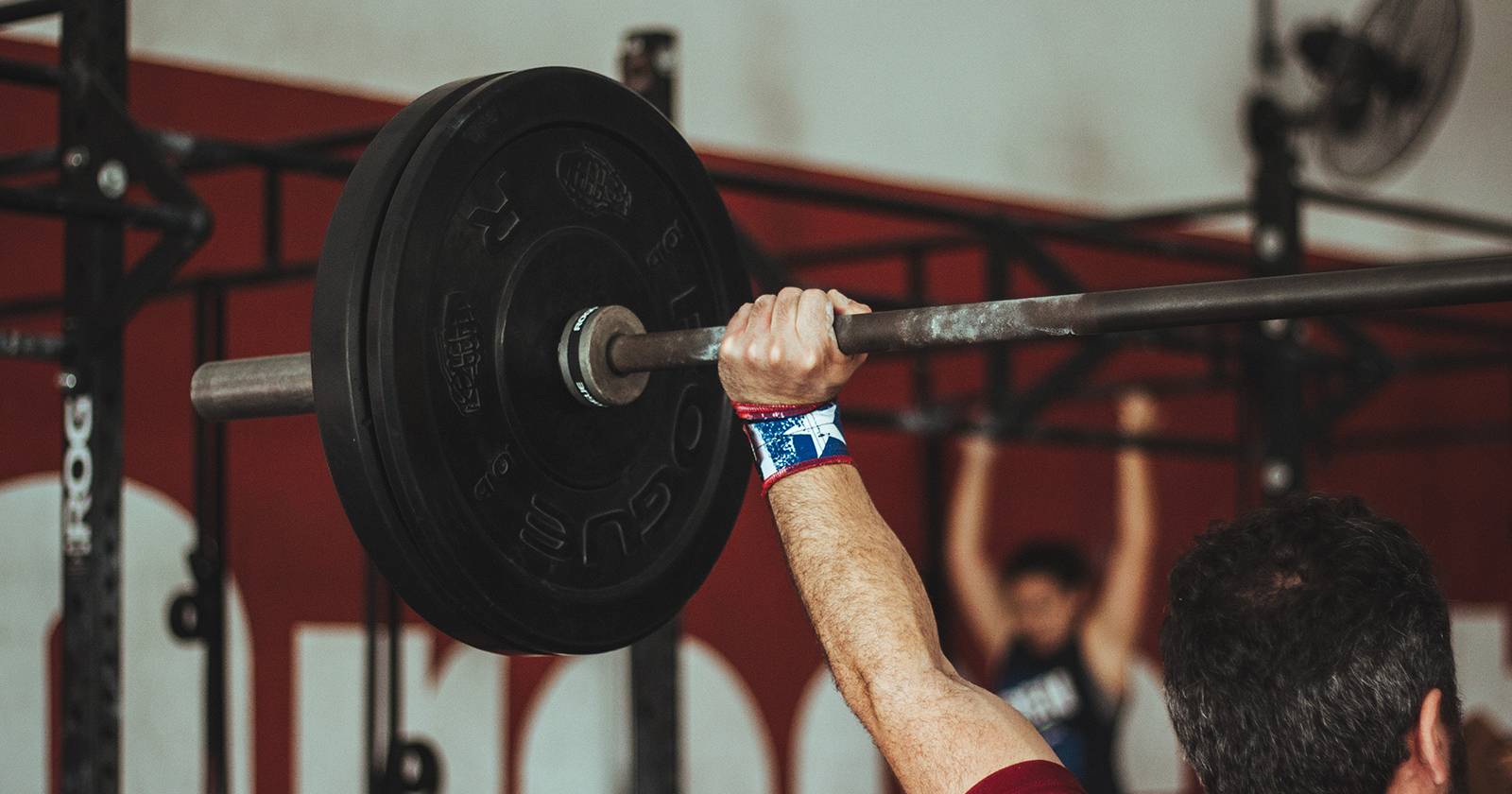 Человек поднимает штангу.