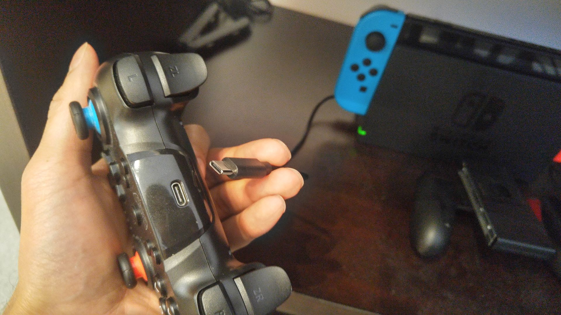 Держание кабеля USB‑C около разъёма USB‑C контроллера Nintendo Switch.