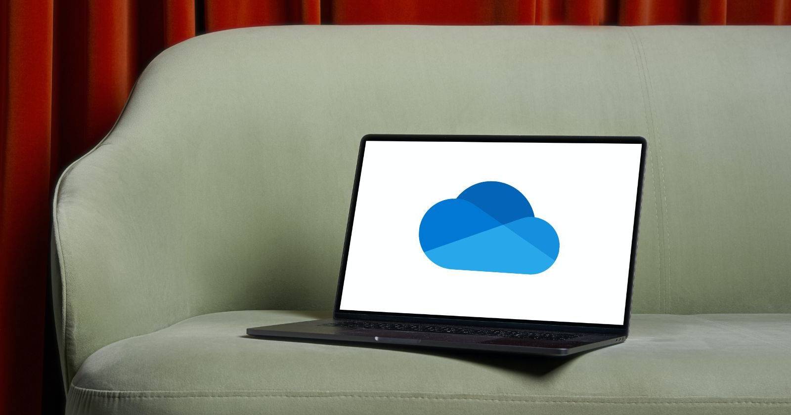 Чёрный ноутбук на диване с открытым приложением OneDrive
