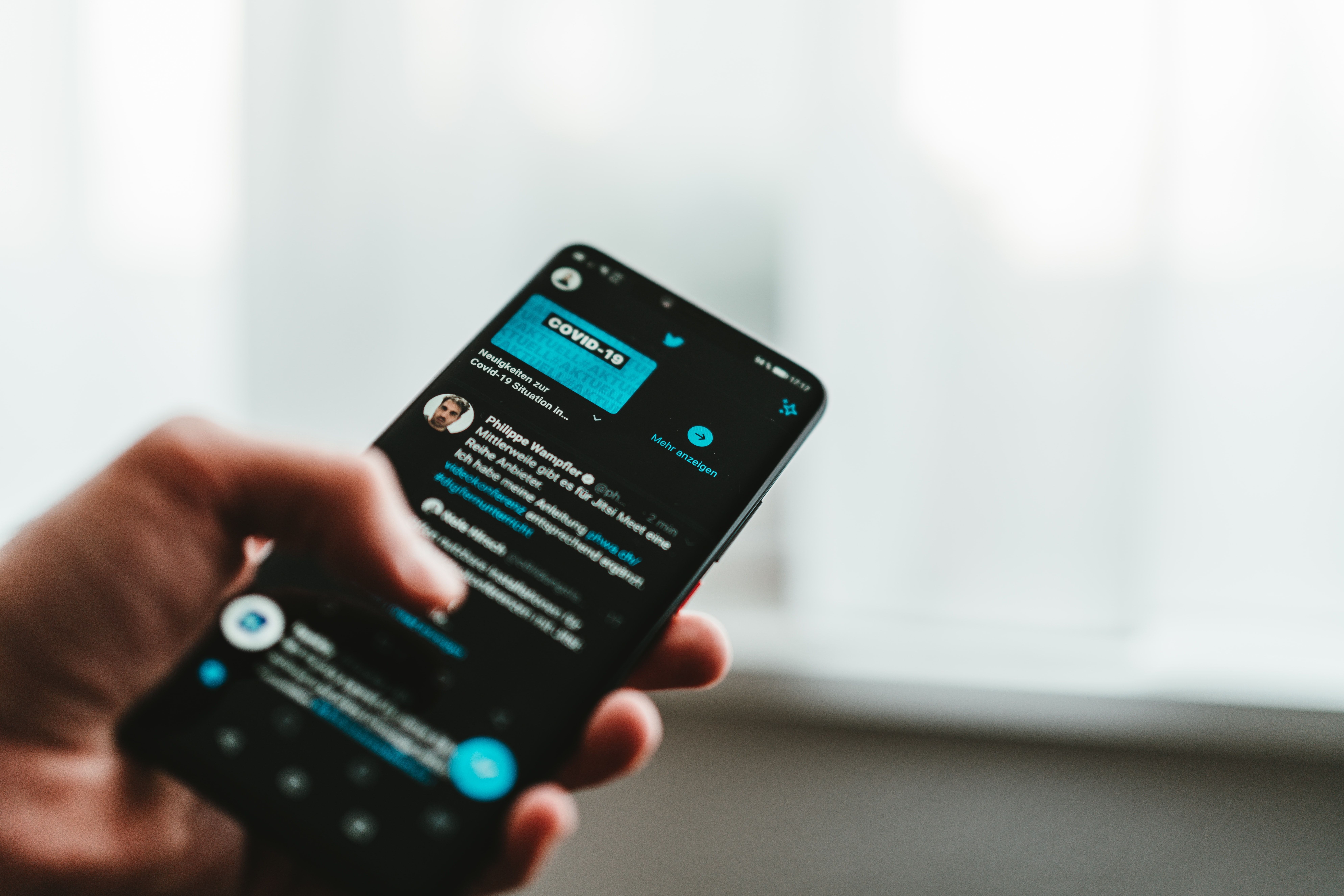 человек с телефоном, экран Twitter
