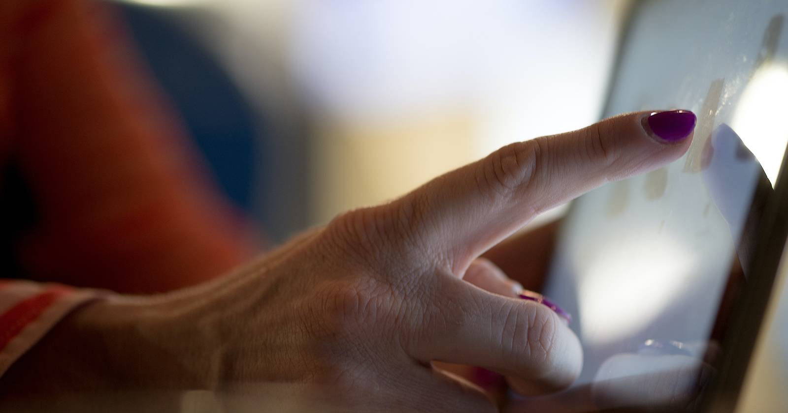 Eine Hand berührt ein Touchscreen-Display