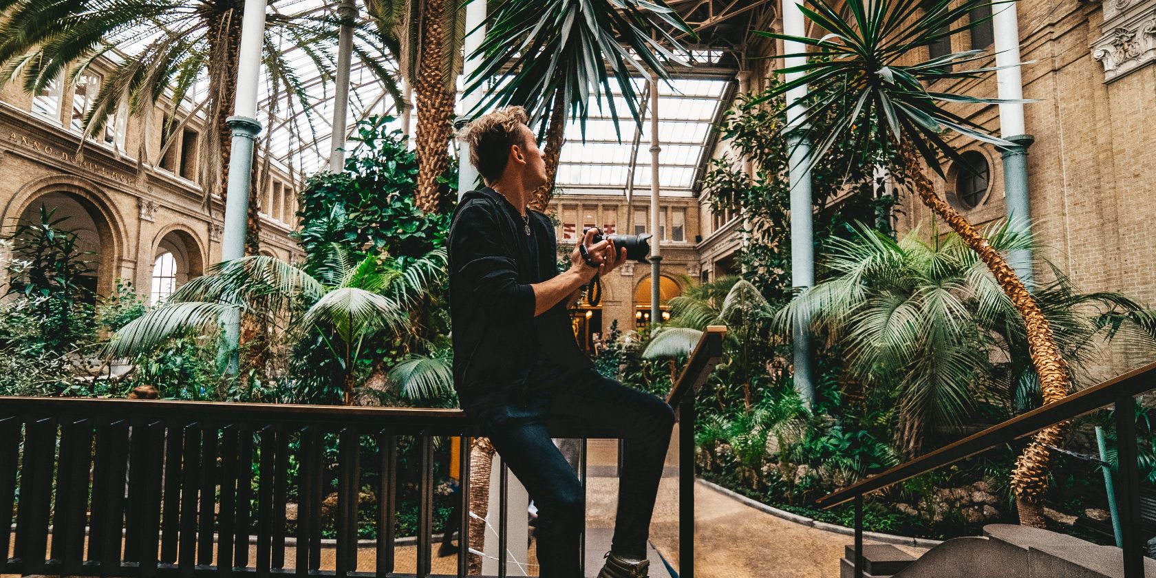 Фотограф в теплице среди растений