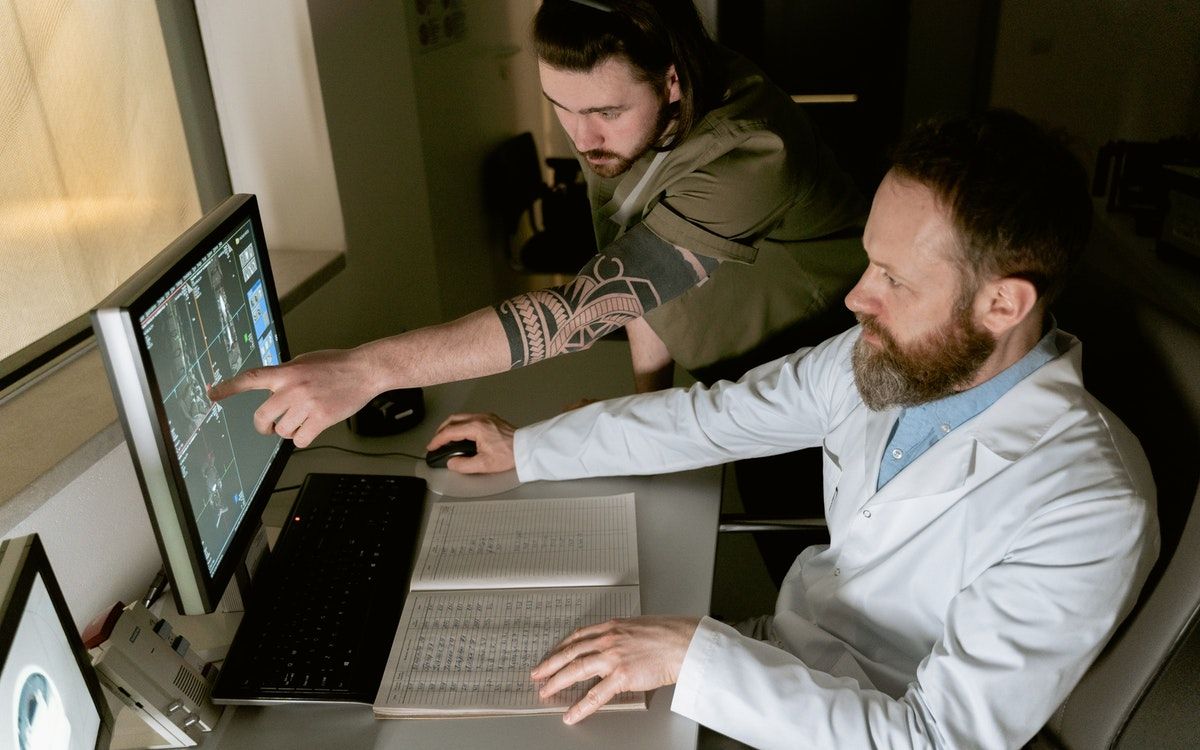 Два человека работают за компьютером, обсуждают документ