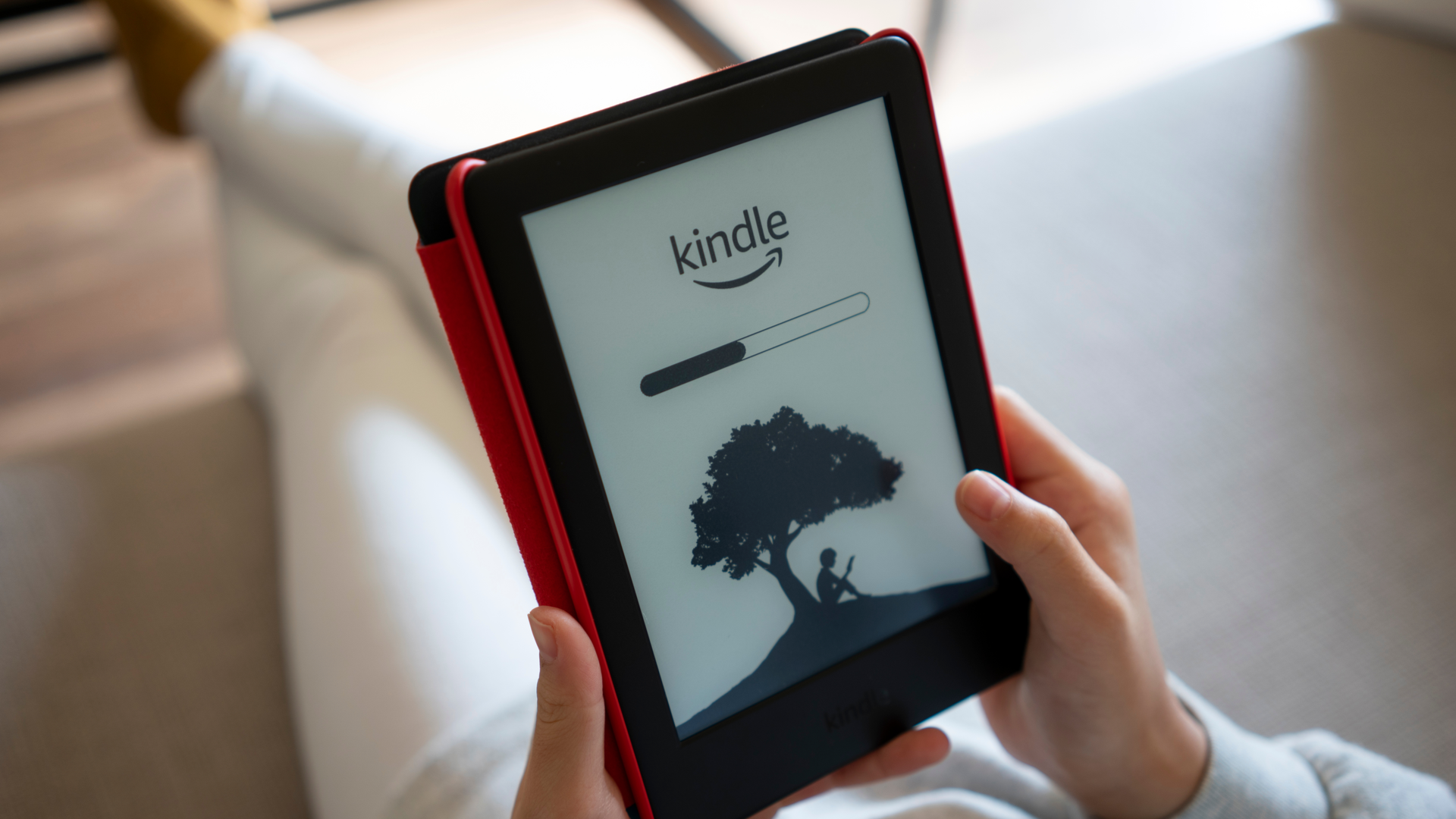 Крупный план логотипа Kindle и индикатора загрузки на экране Amazon Kindle ebook reader