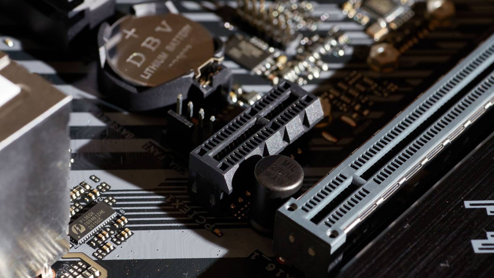 Крупный план слота PCIe на материнской плате, видны контакты и крепёжные отверстия.