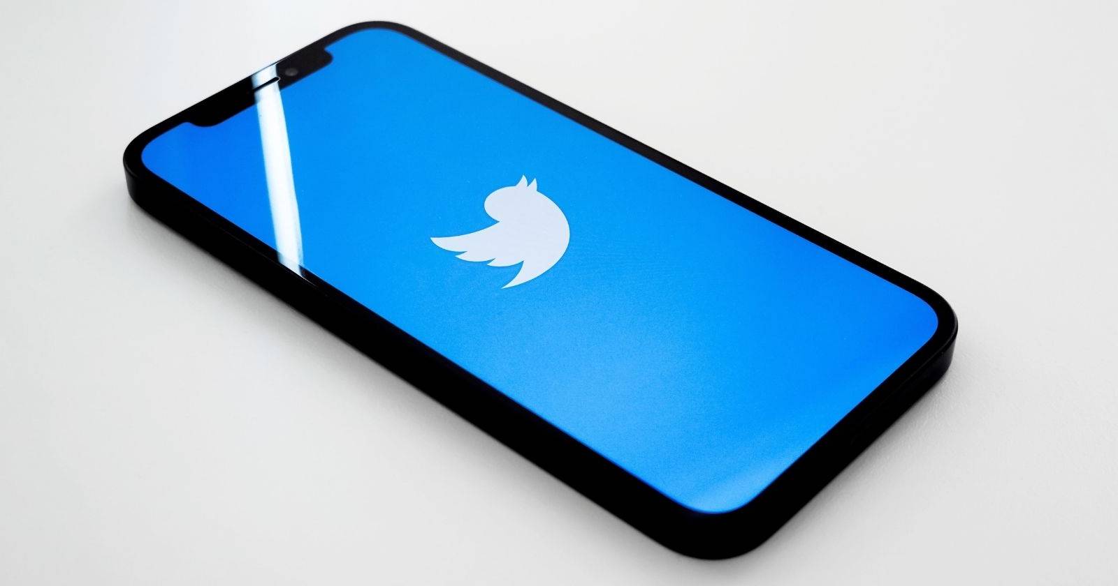Мобильный телефон с логотипом Twitter на синем фоне