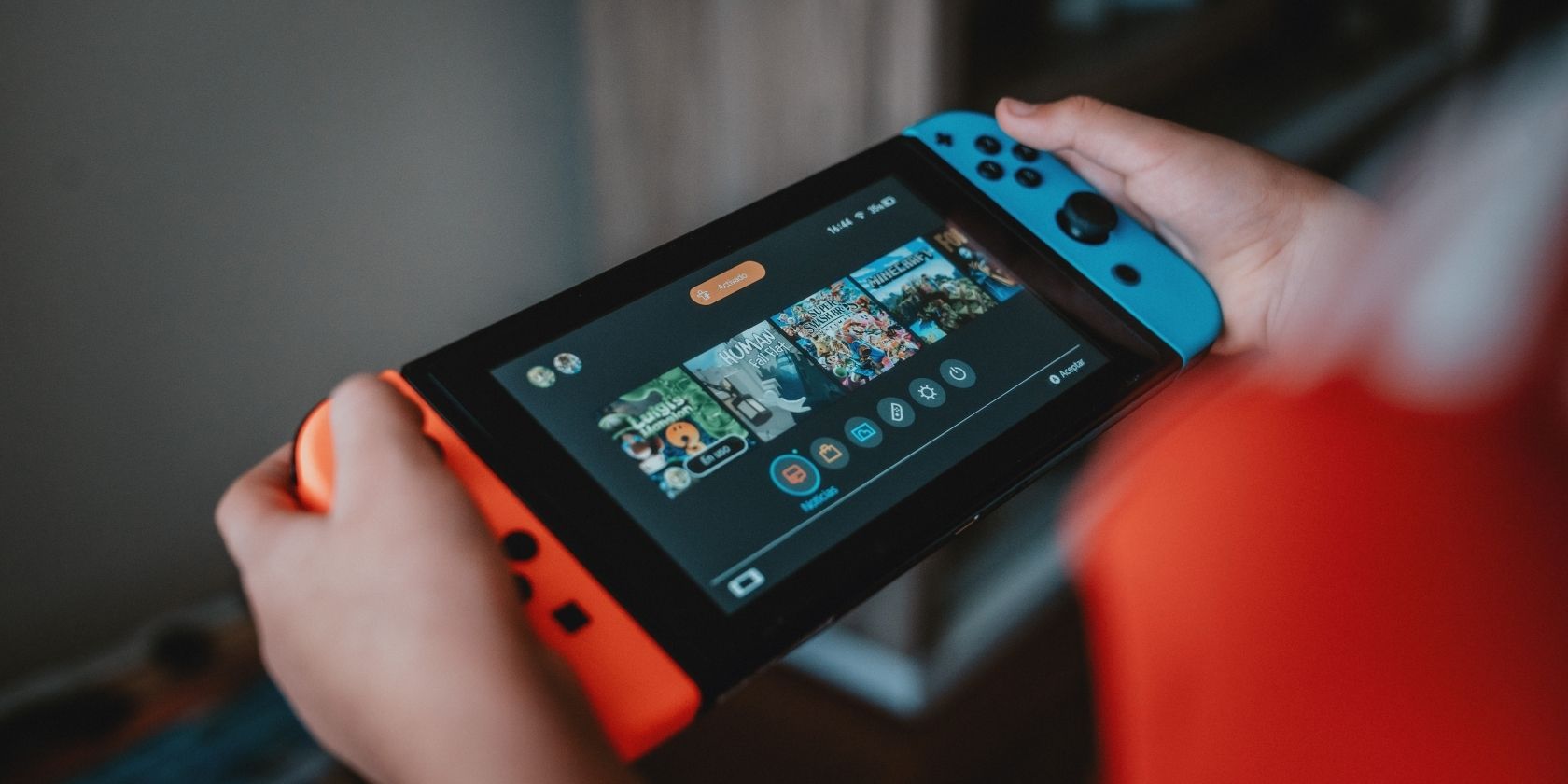 Игрок использует Nintendo Switch в портативном режиме, крупный план рук и экрана