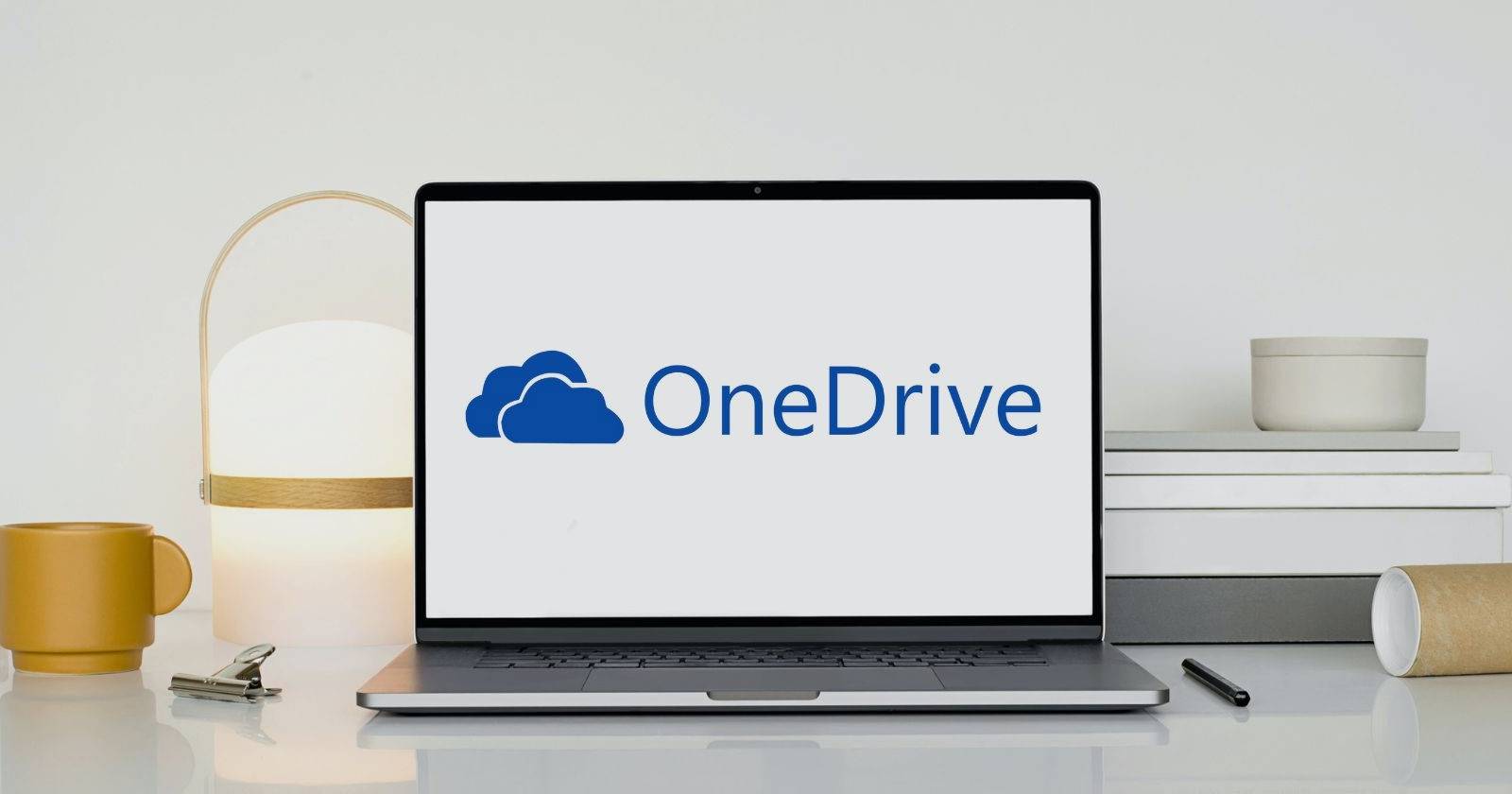 Ноутбук со значком OneDrive на белом деревянном столе
