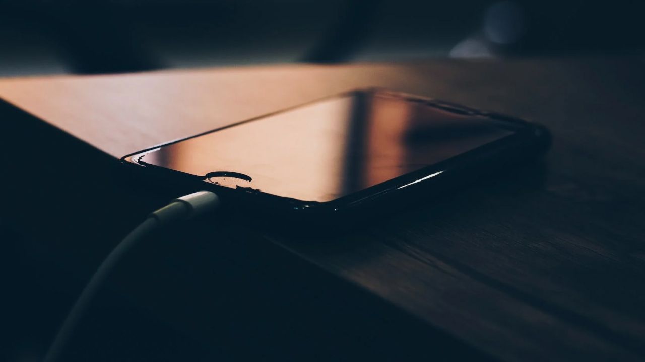 iPhone на столе заряжается проводом