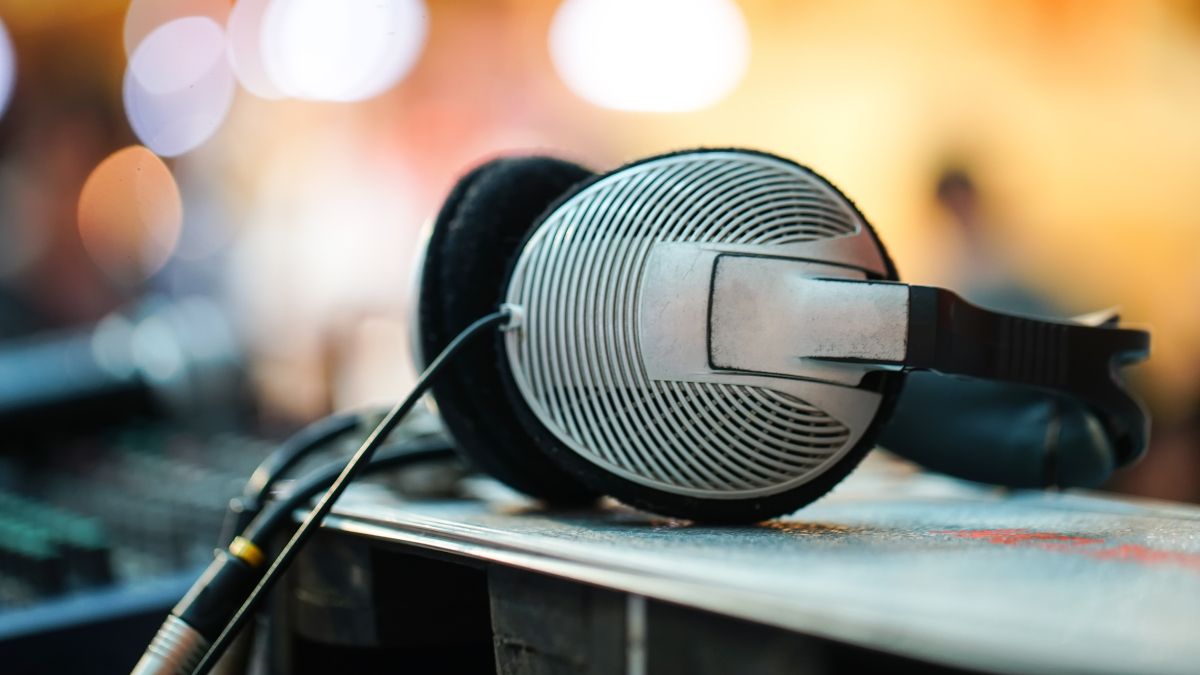 Пара проводных наушников на столе с инженерным оборудованием на заднем плане