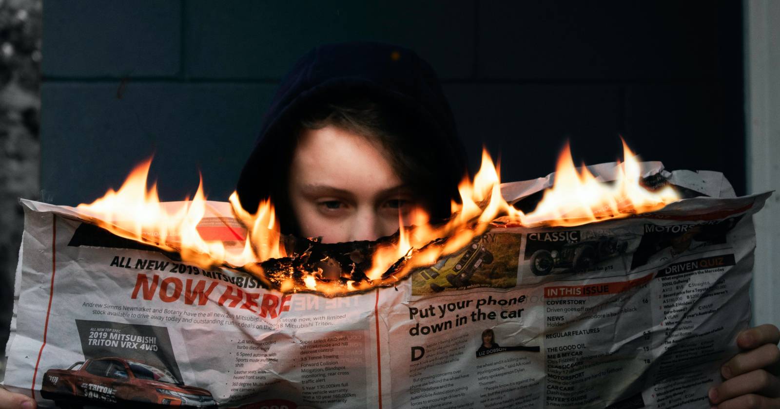 человек читает горящую газету