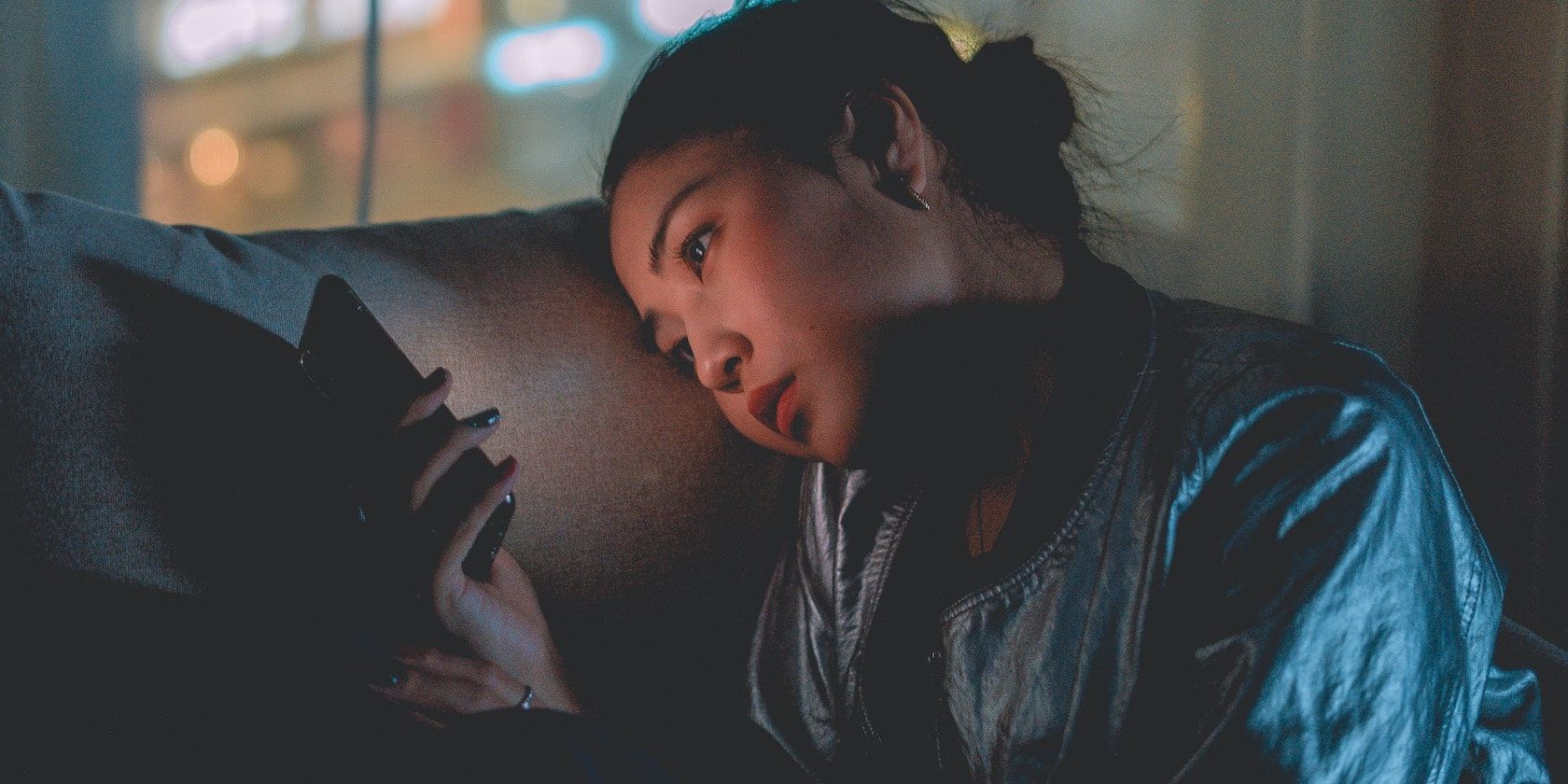 Женщина пользуется телефоном в темноте