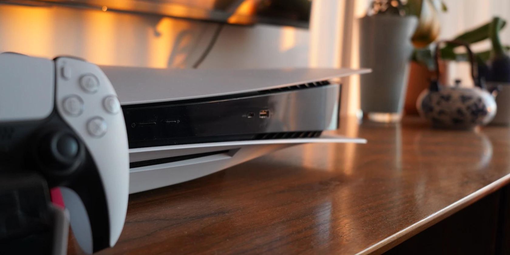 Крупный план PS5 на тумбе рядом с телевизором
