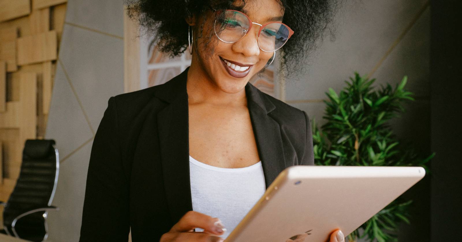 Женщина в чёрном пиджаке использует iPad