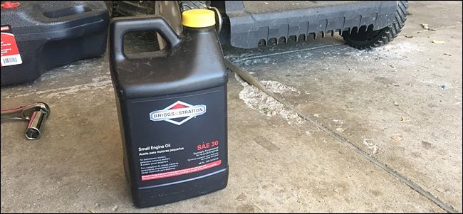 Залив свежего масла через воронку в бензокосилку