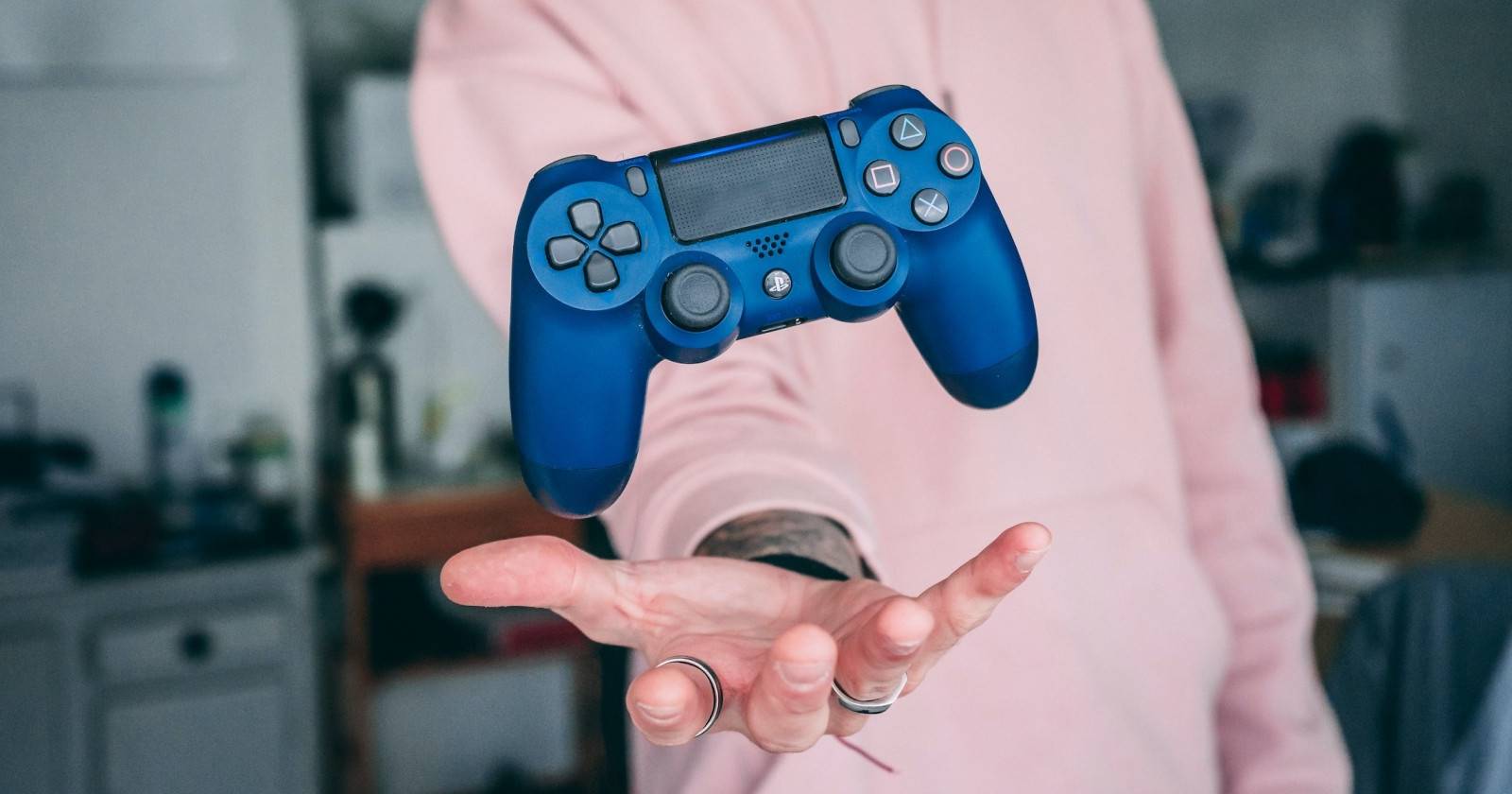 синий игровой контроллер Nobara над рукой человека
