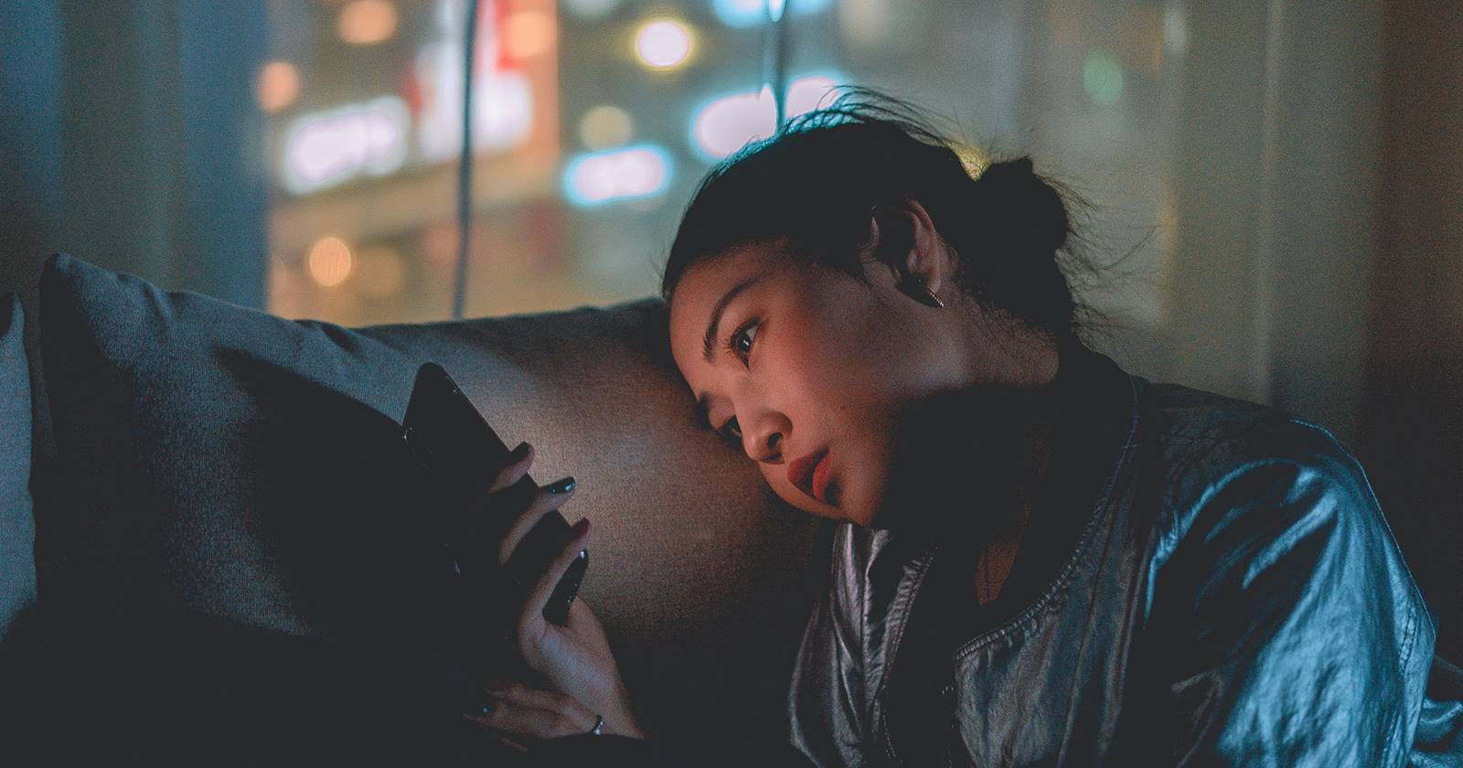 Человек использует телефон на диване