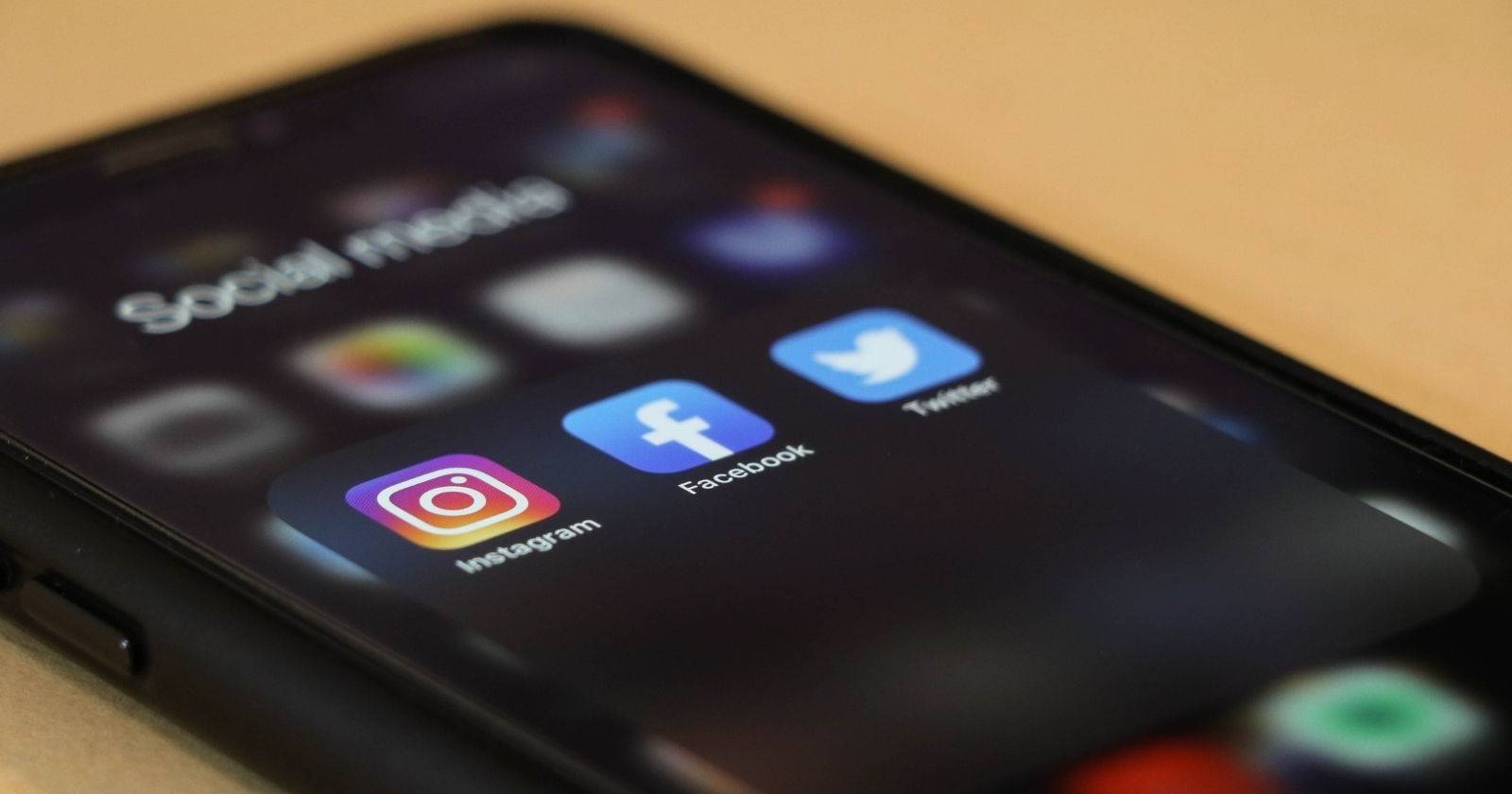 черный iPhone с папкой социальных приложений